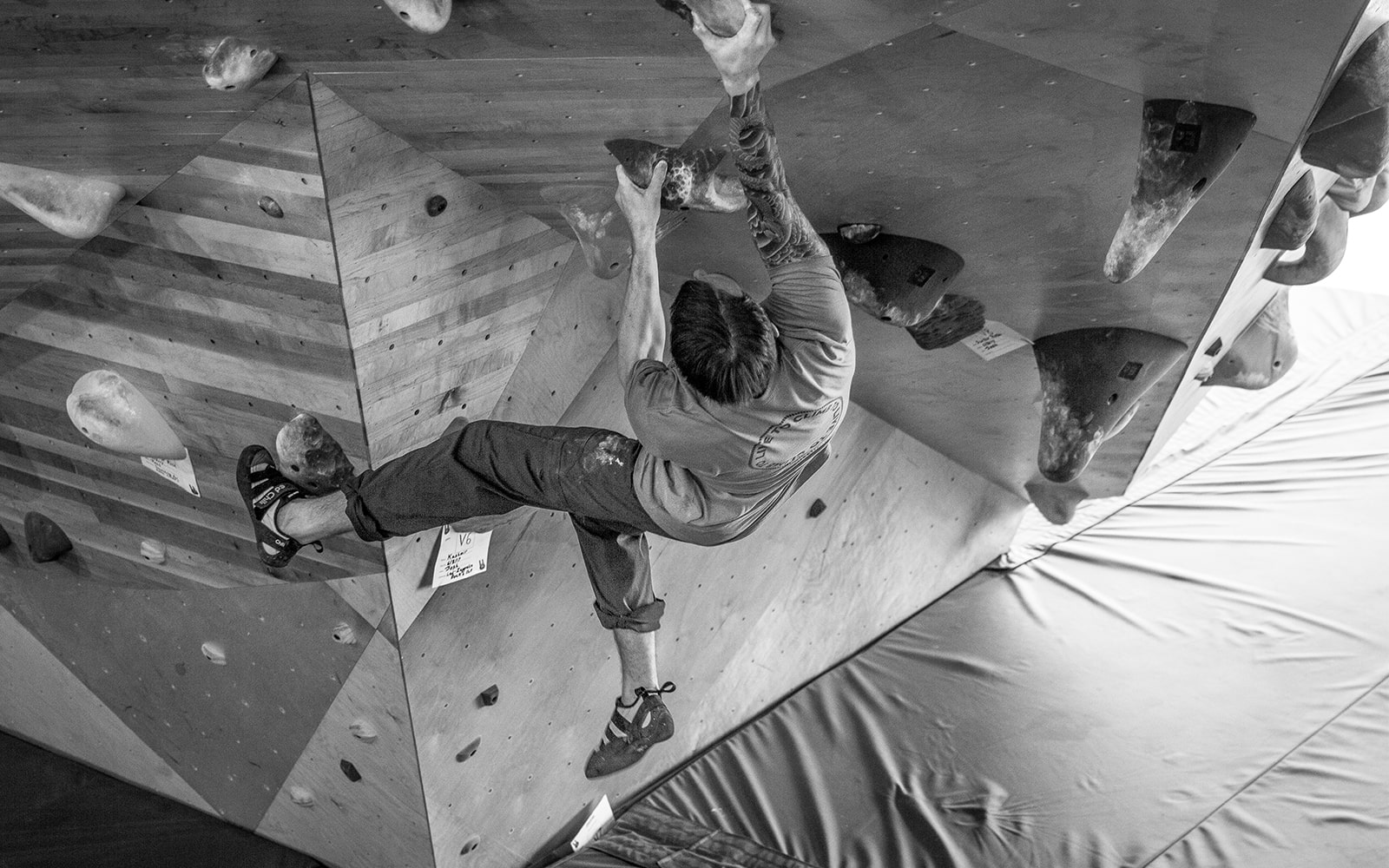 Man on climbing wall at indoor rock climbing gym