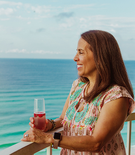 Woman drinking wine in front of the water